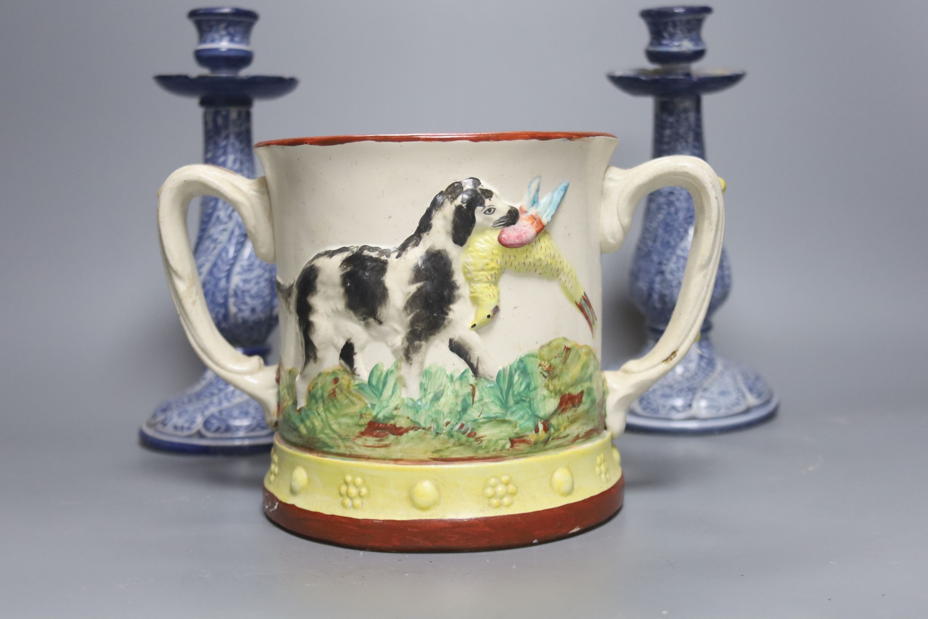 A Staffordshire pottery ‘duck’ tureen and cover, 23cm, a pair of faience candlesticks, Staffordshire figures of dogs, sheep and a zebra and a two handled loving mug